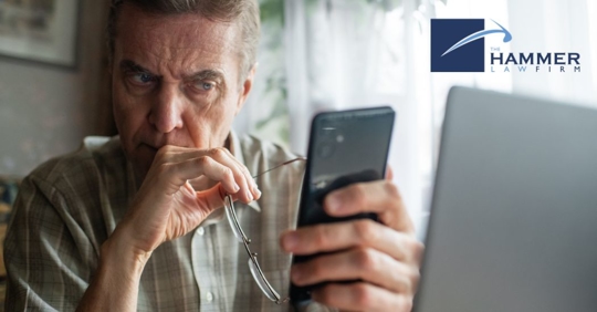 man looking at his phone and laptop