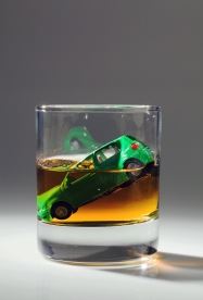 A glass of whiskey with a toy car in the glass